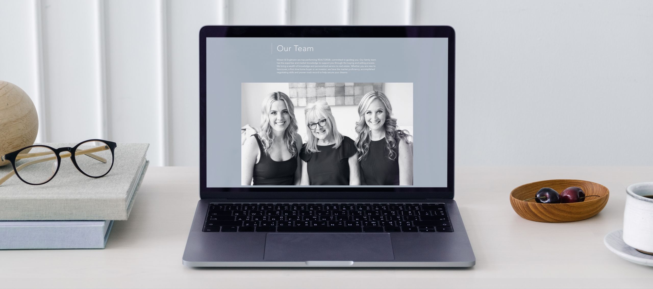 Laptop showing the website for WE Group by Oakwyn Realty.